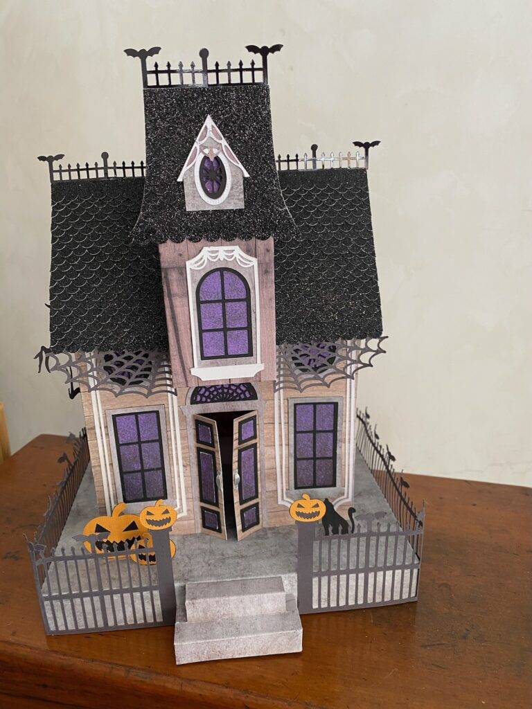 photo d'une maison en papier en trois dimensions créée avec une machine cricut et illuminée pour Halloween